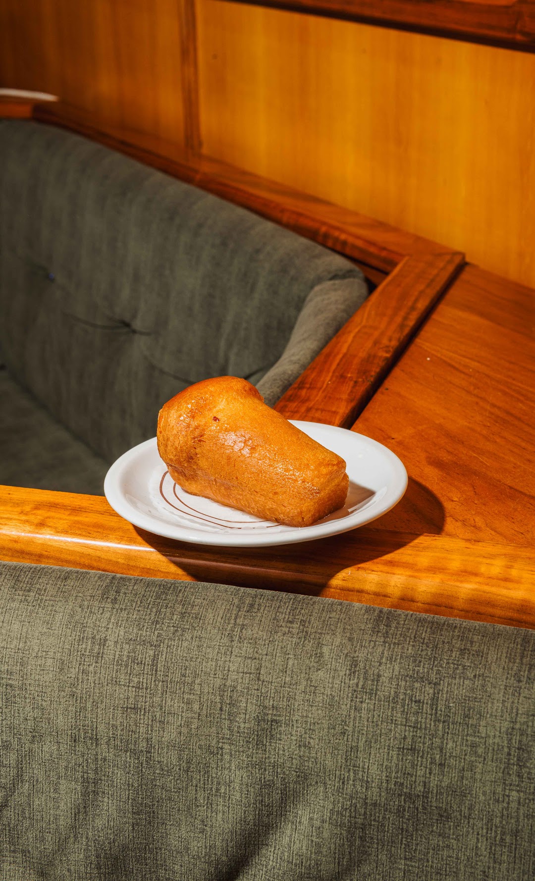 Babà artigianale servito sul divano in velluto verde